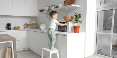 Chlapec stojí u mikrovlnky v kuchyni