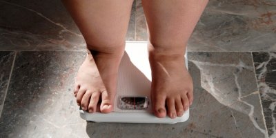 Nohy tlustého člověka na váze