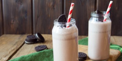 Oreo shaky ve dvou vysokých sklenicím, kolem na stole Oreo sušenky