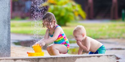 Dvě malé děti v zahradní sprše