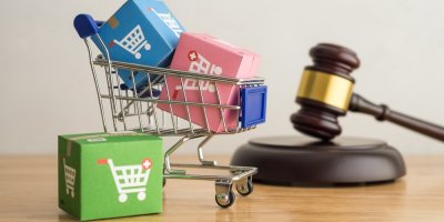 Vozík s kostkami s logem e-shopu, v pozadí soudcovské kladívko