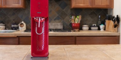Červený přístroj SodaStream na kuchyňské lince