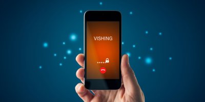 Ruka držící smartphone s varováním před vishingem