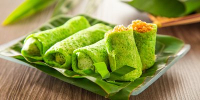 Zelené palačinky s náplní na listech palmy, položené na talířku