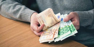 Papírová eura v ruce