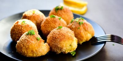 Smažené kuličky na černém talíři