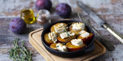 Talířek s pečenými švestkami a hromádkami sýra, okolo švestky a sušený tymián