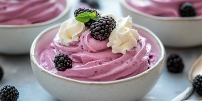 Ostružinová pěna v mističce, ozdobená šlehačkou a ostružinami