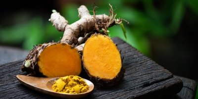 Kořen kurkumy a koření na dřevěné lžičce