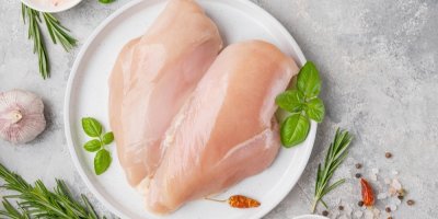 Syrová kuřecí prsa nachystaná k vaření na keramickém talíři