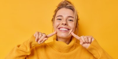 Usmívající se žena ukazuje na své zuby