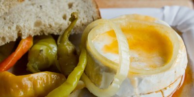 Nakládaný hermelín s cibulí, beraními rohy a chlebem na talíři