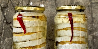 Dvě sklenice s nakládanými hermelíny a chilli papričkami