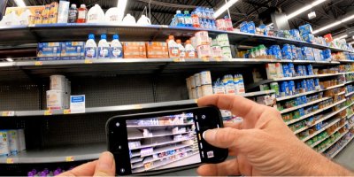 Ruce natáčí telefonem regály v obchodě