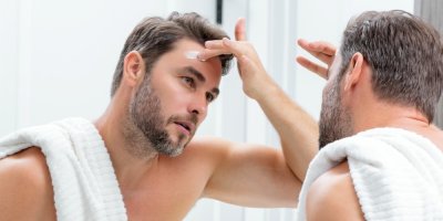 Muž si aplikuje pleťový krém