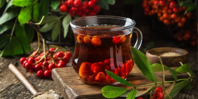 Sklenice jeřabinového čaje a jeřabiny