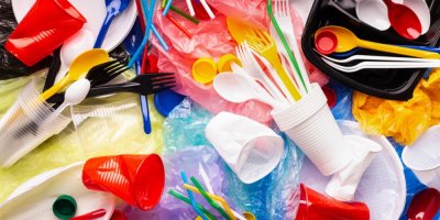 Různé plastové kelímky, brčka a příbory na hromadě