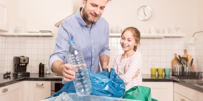 Muž a dívka třídí doma plastové lahve