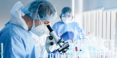 Vědci v laboratoři zkoumají něco mikroskopem