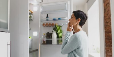 Žena se dívá do otevřené lednice