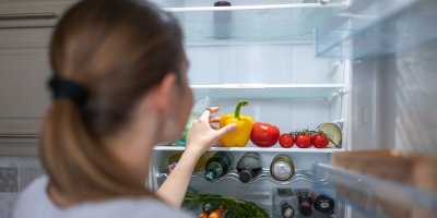Žena do lednice vkládá papriky