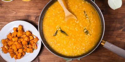 Rýže ve vývaru na pánvi a kostky dýně vedle na talířku