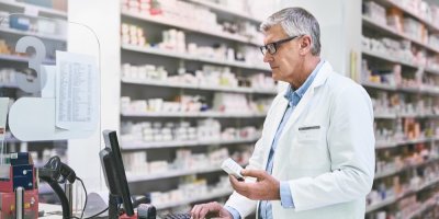 Starší lékárník se dívá do počítače