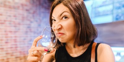 Žena si čichá ke sklenici s vínem