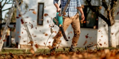 Muž fouká listí fukarem