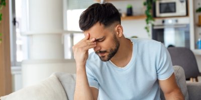 Mlasý muž se rukou drží za hlavu