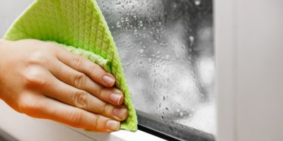 Ruka s hadříkem otírající orosené okno