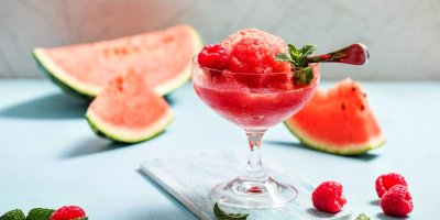 Melounový sorbet ve skleničce, meloun a maliny v pozadí