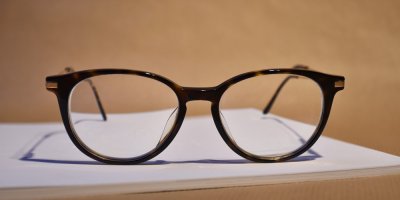 Brýle s černou obroučkou na stole