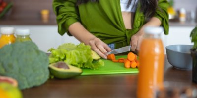 Žena krájí mrkev na plastovém prkénku