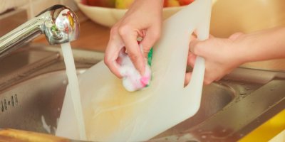 Žena umývá plastové prkénko