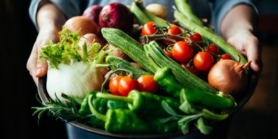 Ruce držící mísu plnou čerstvé zeleniny