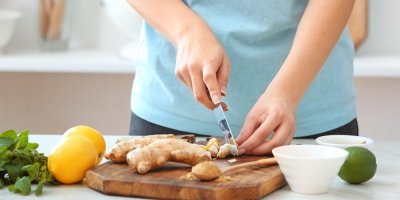 Žena krájí zázvor na kuchyňském prkénku