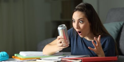 Dívka se udiveně dívá na plechovku