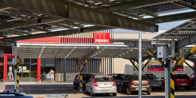 Zastřešené parkoviště se solárními panely před prodejnou PENNY