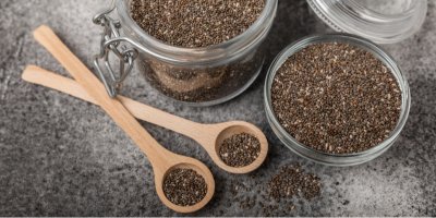 Chia semínka v misce, nádobě a dřevěných lžících