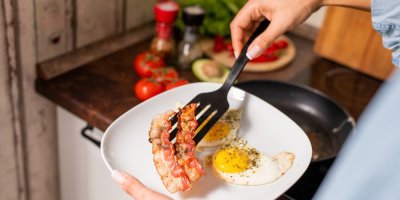 Žena připravila k snídani smaženou slaninu a volská oka