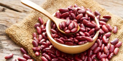 Červené fazole v misce, dřevěná lžíce
