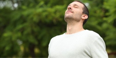 Mladý muž si vychutnává dýchání v přírodě