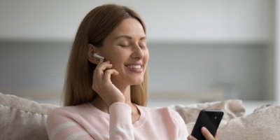 Žena poslouchá hudbu z bezdrátových sluchátek.