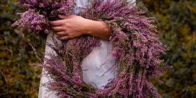 Žena drží v ruce věnec z vřesu