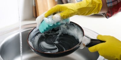 Ruce umývají houbičkou nádobí