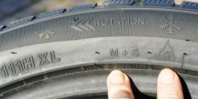Detail zimní pneumatiky s písmeny M+S a hory s vločkou