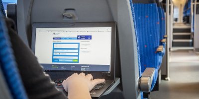 Cestující ve vlaku si kupuje jízdenku online.