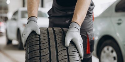 Automechanik drží pneumatiku