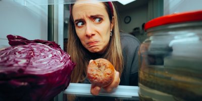 Žena vytahuje zkažené ovoce z lednice